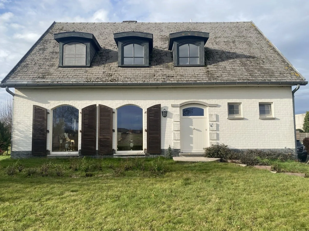 Landelijke woning in wit gevelsteen waarvan Vitra Porta alle ramen en de voordeur verving