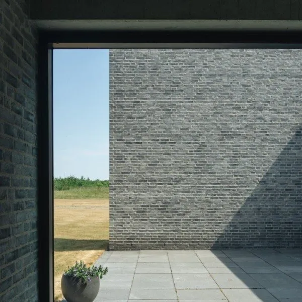 Aluminium raampartij in een gevel in grijze steen, geplaatst door Vitra Porta